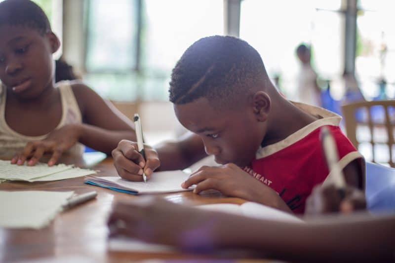 Student writing notes on a piece of paper